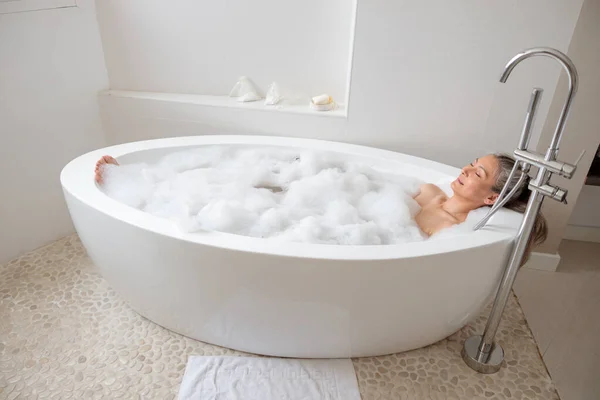 Dame liegt in der Badewanne im Badezimmer — Stockfoto