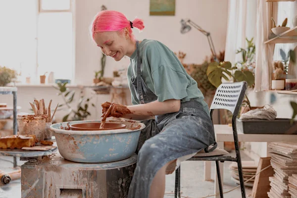 Skillful perempuan pembuat tembikar menciptakan mangkuk tanah di lingkaran di ruang kerja — Stok Foto