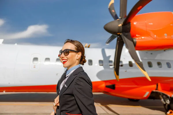 Veselé ženy letušky kráčející po letišti — Stock fotografie