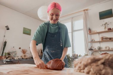 Genç usta seramik atölyesinde kil ürünü kalıba döküyor.