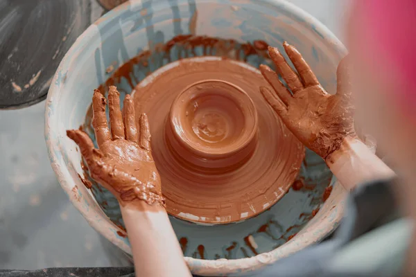 Vrouw pottenbakker beeldhouwen schotel uit klei klomp in atelier — Stockfoto