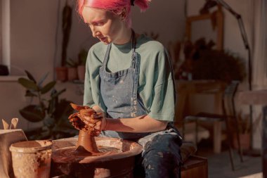 Potter, çalışma odasındaki çömlek çarkında elle çalışıyor.