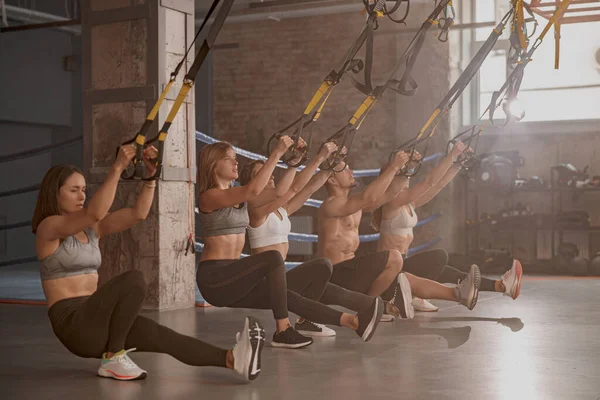 Groep jonge fitnessmensen met fitnessbanden in de sportclub — Stockfoto