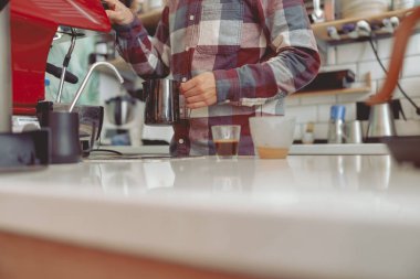 Kafede kahve makinesinin yanında çalışan erkek barista.