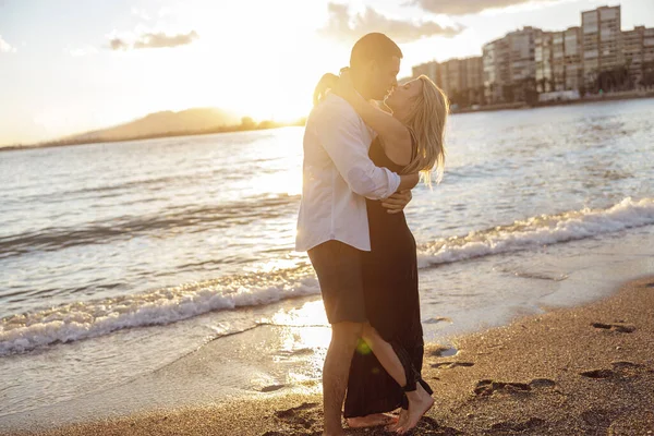 Pasangan berbahagia berpelukan saat berdiri di pantai — Stok Foto
