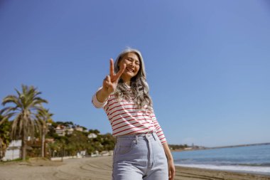 Denizde poz veren mutlu yüzlü kendine güvenen bir kadın.