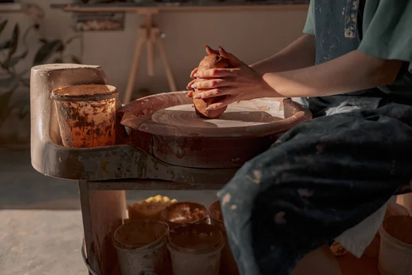Giovane vasaio che lavora sulla ruota della ceramica in officina — Foto Stock