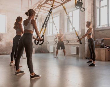 Gençler spor salonunda antrenman yapıyor.