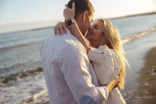 Portrait of carefree couple kiss while standing on shore — Stok Foto