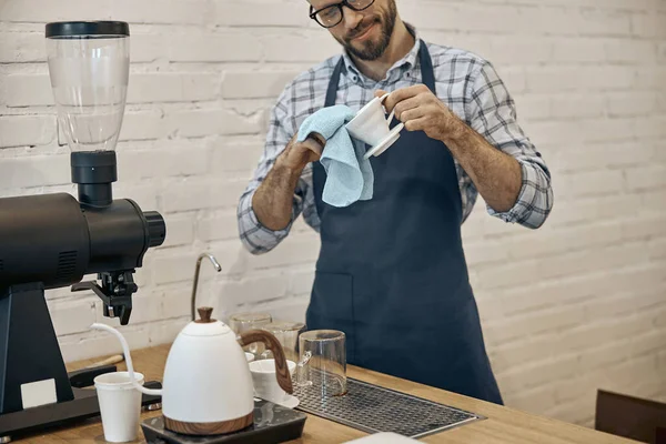 Férfi munkás kötény tisztító csésze kávézóban — Stock Fotó