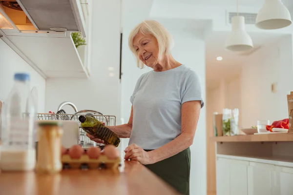 Masa pensiun wanita tampan memasak makanan di dalam ruangan. — Stok Foto
