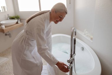 Güzel kadın banyo yapmaya hazırlanıyor.