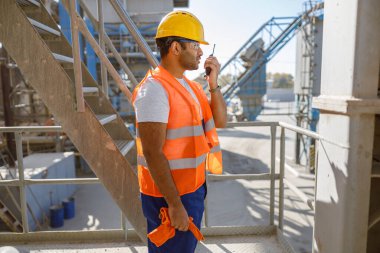 Afrikalı müteahhit dışarıda radyoda konuşuyor.