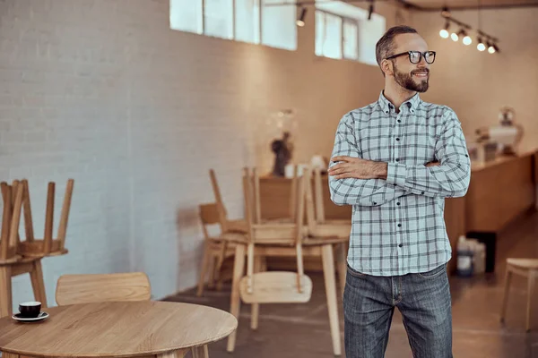 Pria berjenggot gembira berkacamata berdiri di kafe — Stok Foto