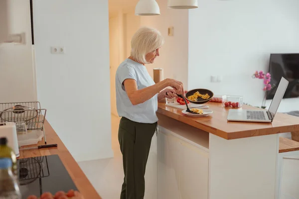 Yaşlı kadın evde sağlıklı bir kahvaltı yapıyor. — Stok fotoğraf