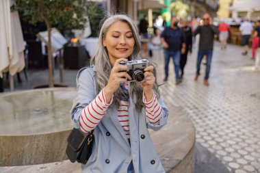 Sokakta fotoğraf çeken tutkulu bir kadın.