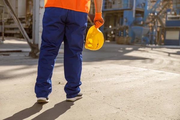 Hüsrana uğramış ustabaşı, fabrikada kasketli.