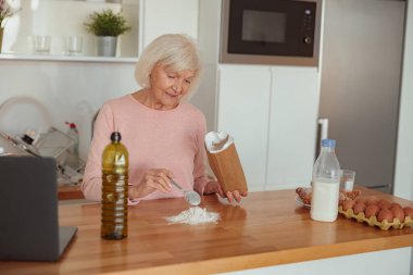 Yaşlı ev hanımı mutfakta bisküvi için para kazanıyor.