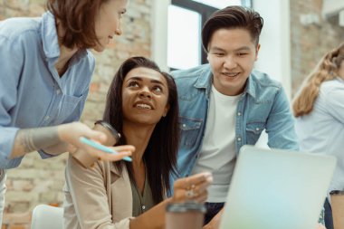 Toplantıda dizüstü bilgisayar kullanan akıllı iş ortaklarının portresi.