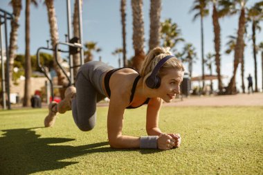 Şehir parkında spor yapan genç bir kadın.
