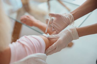 Hemşire oturma odasında yaşlı kadına iğne yapıyor.