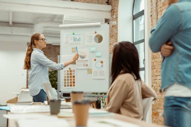 İş kadını masadaki meslektaşlarına proje istatistiklerini sundu