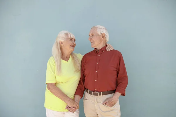 Счастливая позитивная пожилая женщина и любящий мужчина обнимаются на светло-сером фоне — стоковое фото