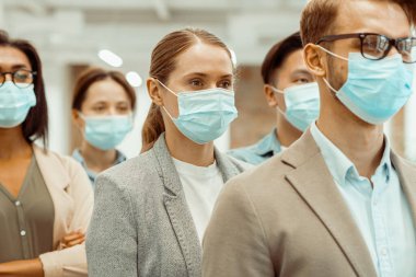 Çok uluslu iş adamları koruyucu maske takıyor.