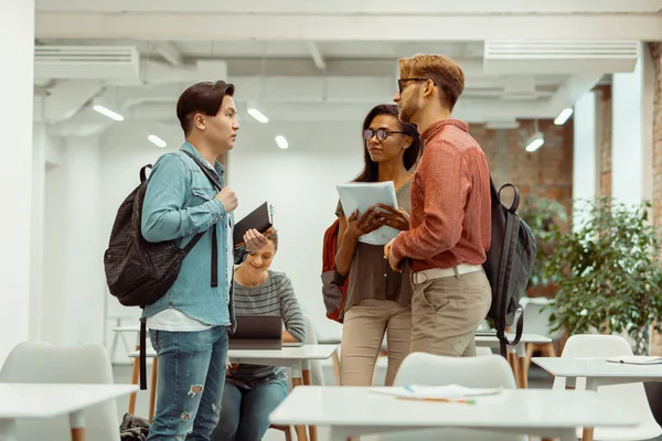 Étudiants avec des sacs à dos debout et tenant des carnets — Photo