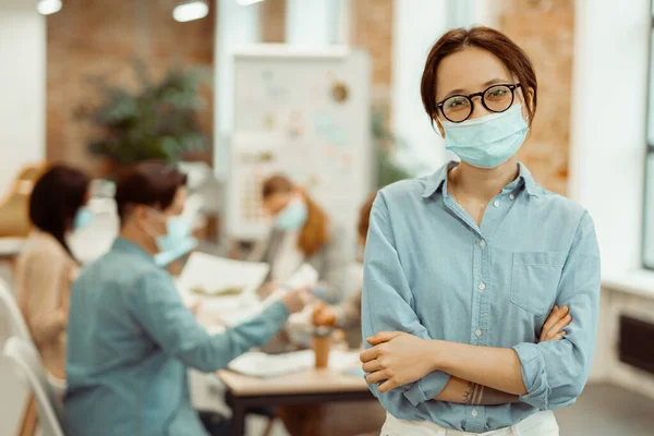 Mujer con una máscara protectora mientras trabaja en la oficina — Foto de Stock