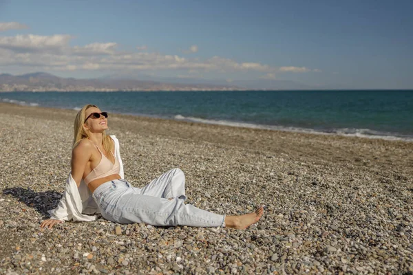 Yaz tatilinde boş bir sahilde eğlenen hayat dolu bir kadın.