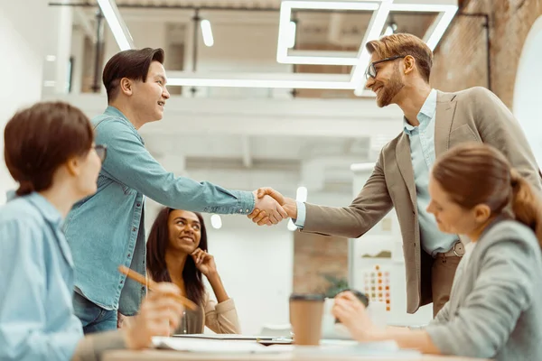 Dva usměvaví muži potřesou rukou v kanceláři — Stock fotografie