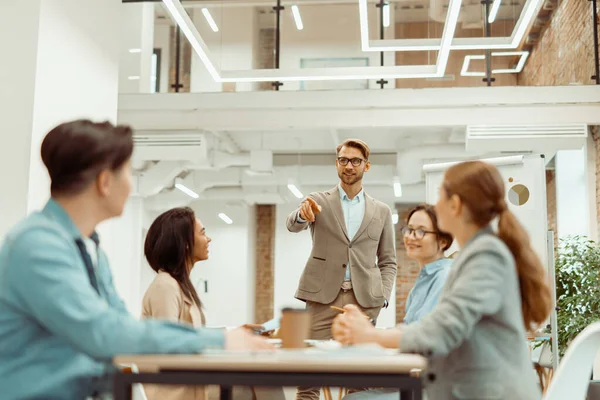 Leader standing in office and explaining new ideas to colleagues — Photo