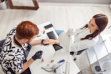 Manikür ustası güzellik salonunda profesyonel manikür yapıyor.