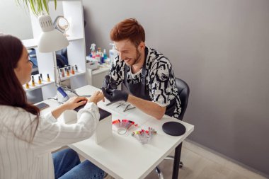 Beyaz kadın güzellik salonunda manikür yaptırıyor.