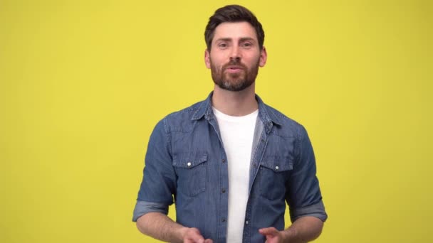 Charismatic male journalist talking to camera actively gesticulating on yellow background in studio — Vídeos de Stock