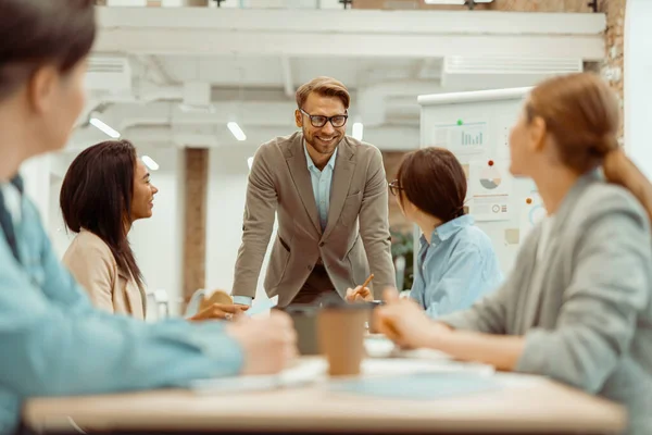 Šťastný muž mluví se svou kolegyní během setkání — Stock fotografie