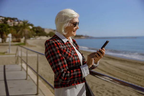 Foto de mulher encantadora usando telefone ao ar livre — Fotografia de Stock