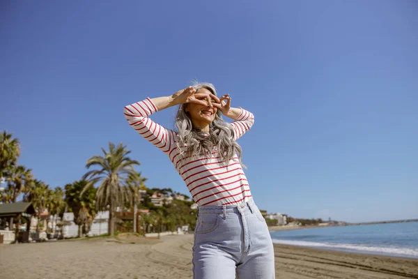 Denizde poz veren mutlu yüzlü kendine güvenen bir kadın.