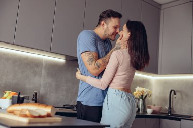 Romantik, mutlu, beyaz bir erkek ve kadın sabah sarılıp öpüşüyorlar..