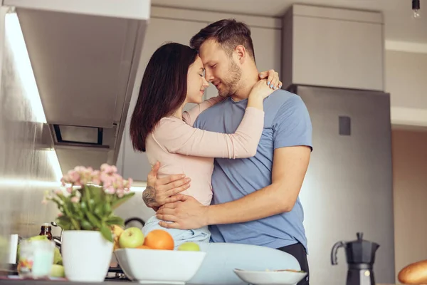 Портрет влюбленной пары, обнимающей домашний интерьер. мужчина и женщина обнимаются на кухне. — стоковое фото
