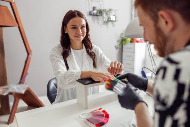 Neşeli kadın güzellik salonunda manikür yaptırıyor.