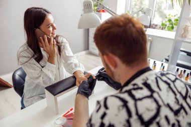 Manikür ustası güzellik salonunda profesyonel manikür yapıyor.