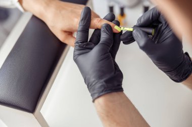 Manikür ustası kuaförde çivi üstünde çalışıyor.