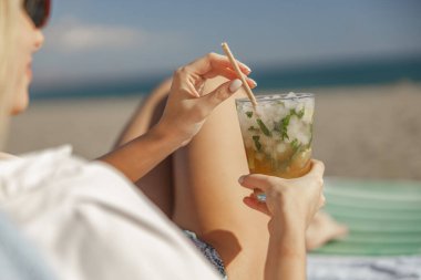 Limonlu mojito kokteyli ve kadın ellerinde viski bardağında nane şekeri.