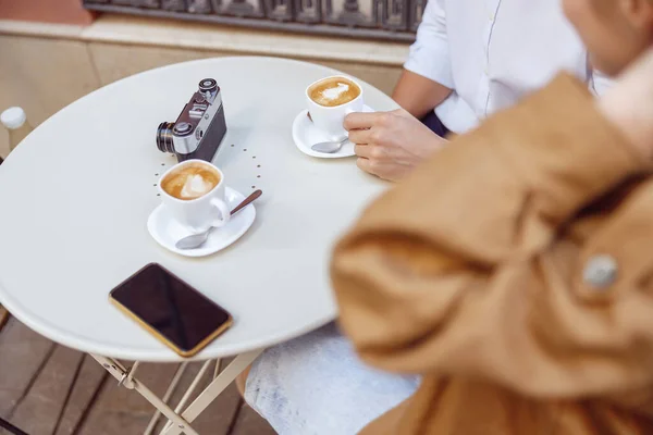 Close-up of man and lady sitting at table with cups of coffee — Stok fotoğraf