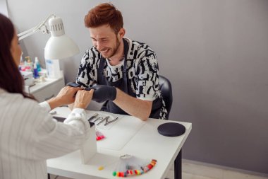 Modern manikür salonunda çalışan deneyimli bir manikürcü.