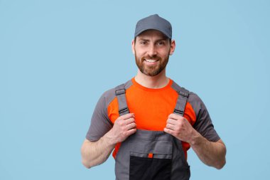 Üniformalı gülümseyen müteahhit portresi tulumunu tutuyor ve kameraya bakıyor.