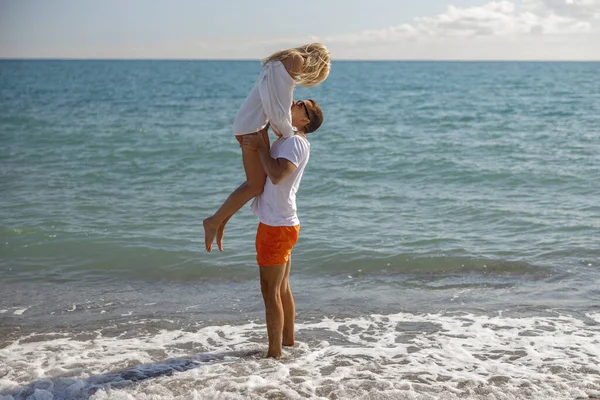 Tampilan samping pasangan bahagia di pantai dengan laut di latar belakang — Stok Foto