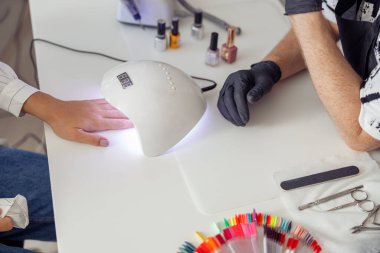 Tırnak manikürü için manikür yaptıran zarif bir kadın.